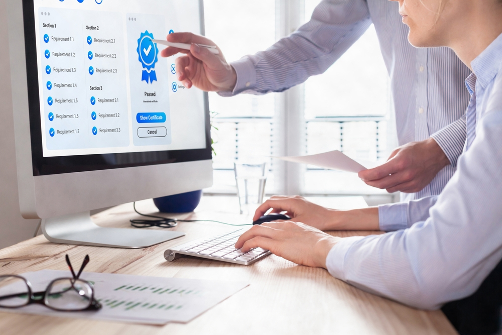 Two individuals collaborating on a computer with a blue icon symbolizing teamwork and technology.3